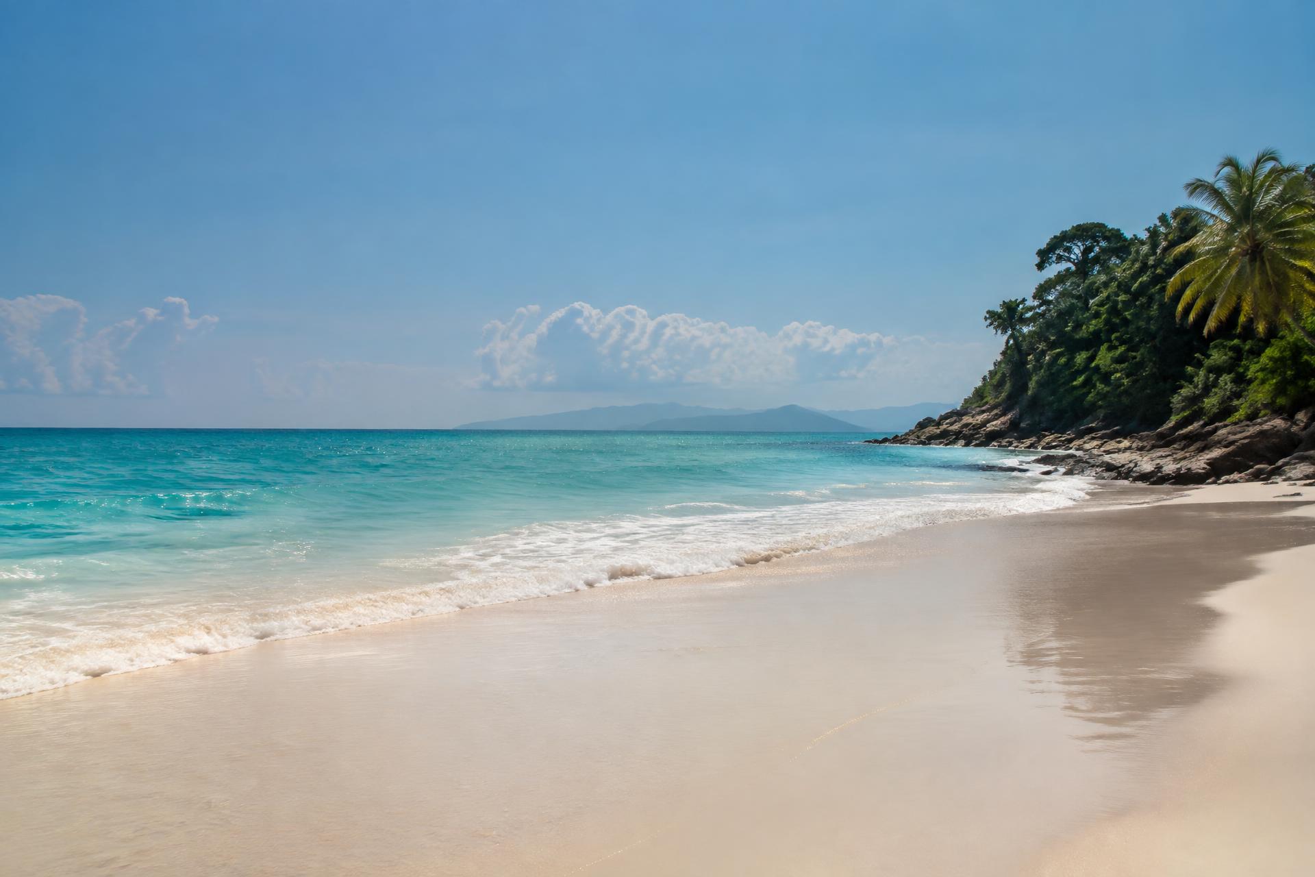 Bright midday sun over turquoise water and warm sand